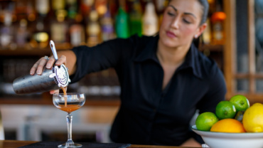 Profesjonalny barman przygotowujący koktajl podczas obsługi mobilnego baru na wesele lub event.