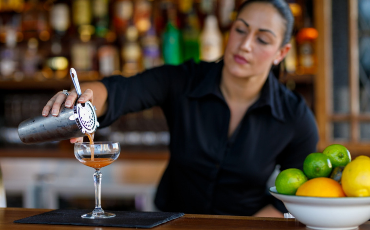 Profesjonalny barman przygotowujący koktajl podczas obsługi mobilnego baru na wesele lub event.