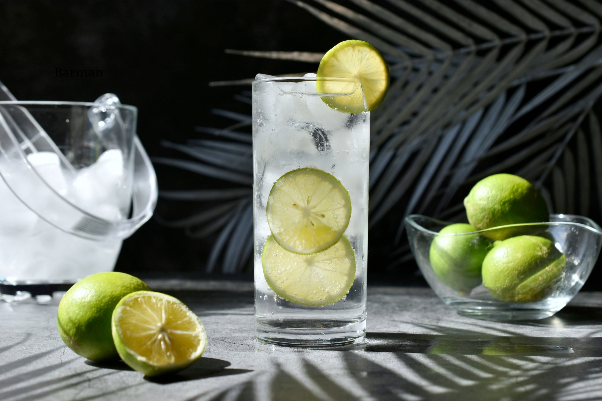 Gin & tonic Gin & Tonic podany z limonką i kostkami lodu w wysokiej szklance.