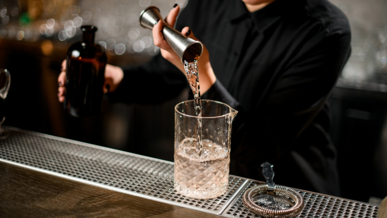 Barman przygotowujący koktajl z użyciem profesjonalnego sprzętu barmańskiego podczas obsługi mobilnego baru.