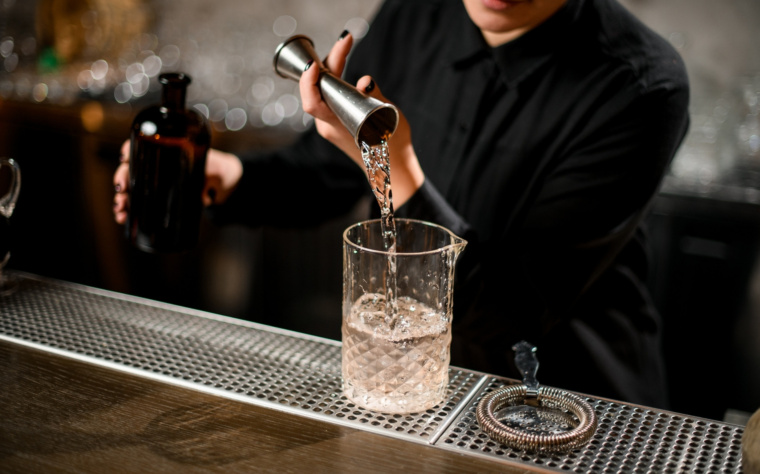 Barman przygotowujący koktajl z użyciem profesjonalnego sprzętu barmańskiego podczas obsługi mobilnego baru.
