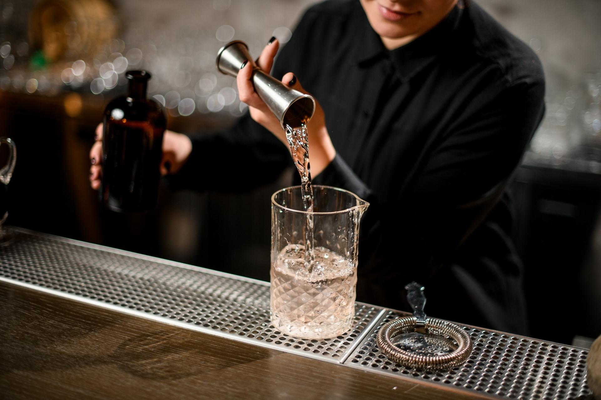 Barman przygotowujący koktajl z użyciem profesjonalnego sprzętu barmańskiego podczas obsługi mobilnego baru.