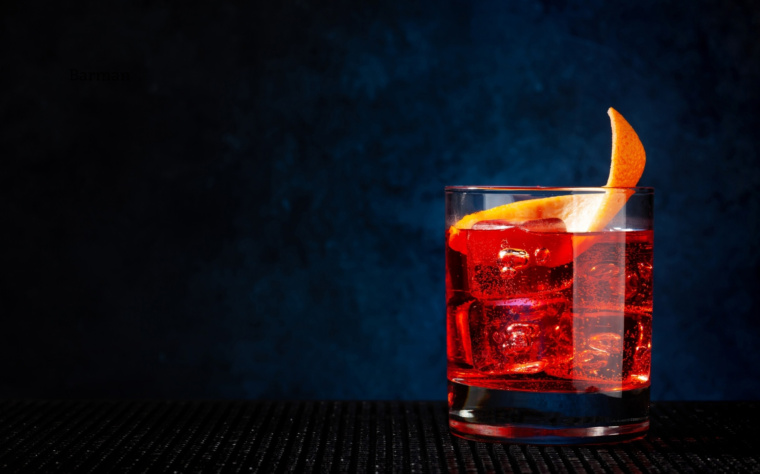 Negroni podane na dużej kostce lodu z twistem ze skórki pomarańczy.